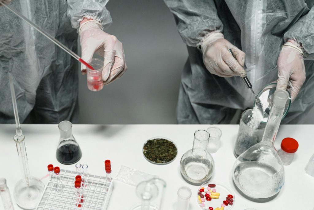 Scientists in protective gear conducting experiments in a modern laboratory setting.